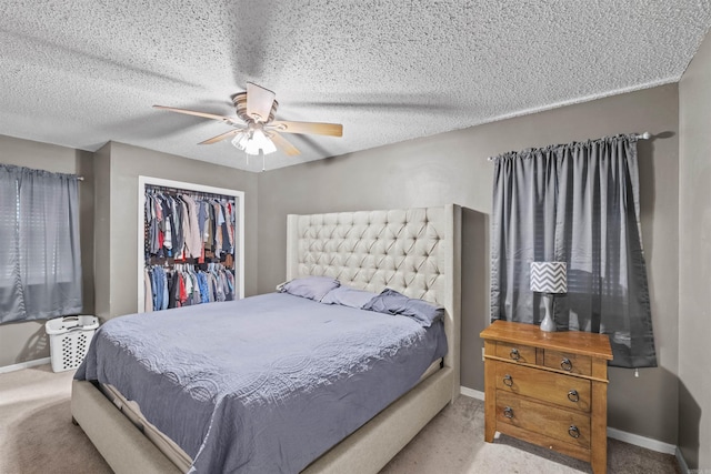 carpeted bedroom featuring ceiling fan, a closet, and a textured ceiling