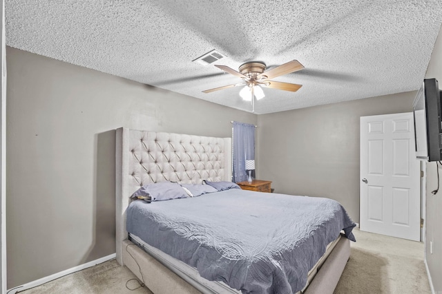 bedroom featuring light carpet, ceiling fan, and a textured ceiling