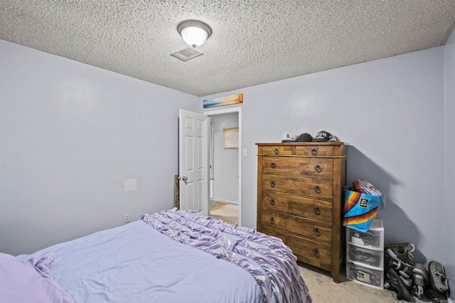 bedroom featuring a textured ceiling and light colored carpet