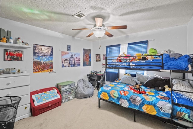 bedroom featuring a textured ceiling, ceiling fan, and carpet