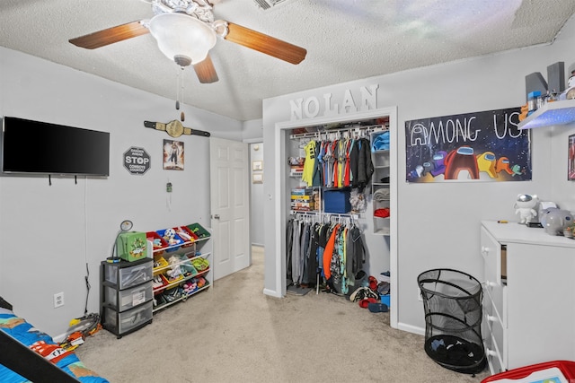 carpeted bedroom with ceiling fan, a closet, and a textured ceiling