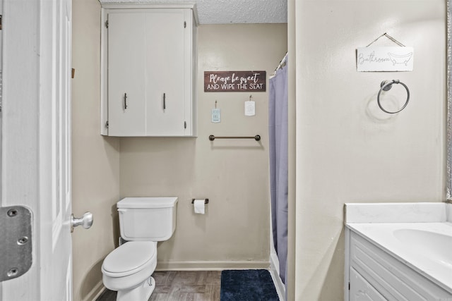 bathroom featuring toilet, vanity, a textured ceiling, and curtained shower