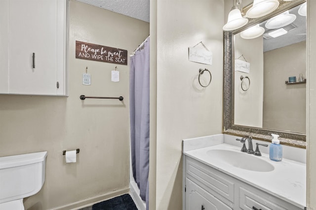 bathroom featuring toilet, a textured ceiling, curtained shower, and vanity