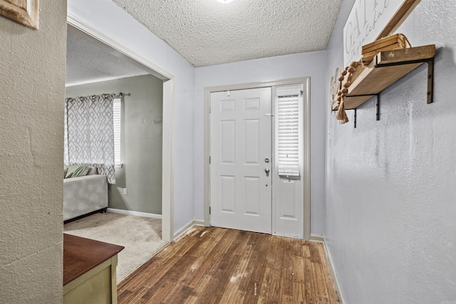 foyer entrance featuring a textured ceiling and dark hardwood / wood-style floors