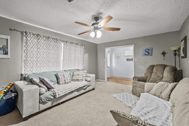 carpeted living room featuring a textured ceiling and ceiling fan