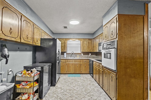 kitchen with a textured ceiling, black appliances, and sink