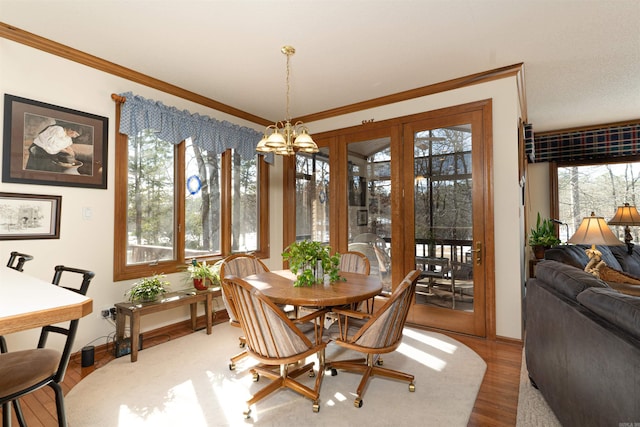 dining room with hardwood / wood-style flooring, crown molding, and a chandelier