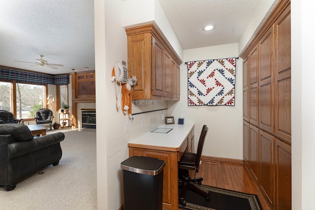 kitchen featuring a textured ceiling, ceiling fan, and light carpet