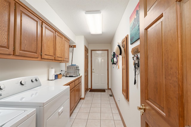 washroom featuring a textured ceiling, light tile patterned floors, cabinets, and independent washer and dryer