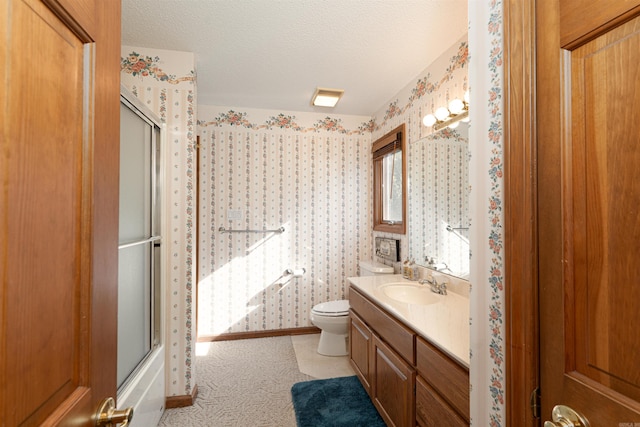 full bathroom featuring toilet, shower / bath combination with glass door, a textured ceiling, and vanity