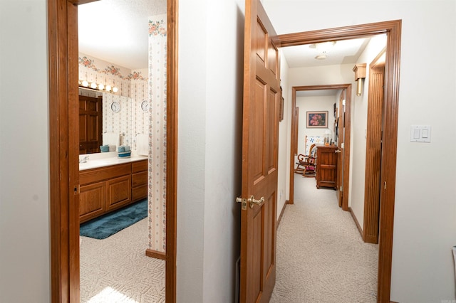 corridor with light colored carpet and sink