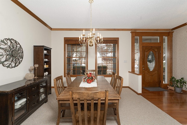 carpeted dining space with ornamental molding and an inviting chandelier