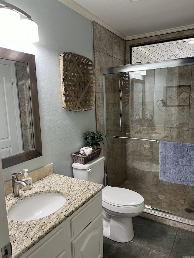 bathroom featuring toilet, vanity, a shower with shower door, and crown molding