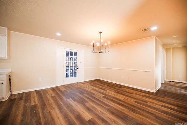 unfurnished dining area with a notable chandelier and dark wood-type flooring