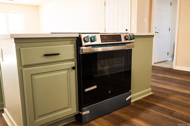 room details featuring dark wood-type flooring, green cabinetry, and stainless steel electric range oven