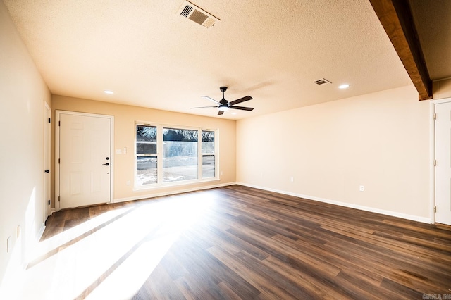 unfurnished room with dark hardwood / wood-style flooring, a textured ceiling, ceiling fan, and beamed ceiling