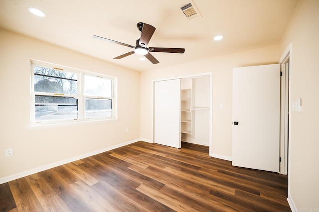 unfurnished bedroom with ceiling fan, a closet, and dark hardwood / wood-style floors