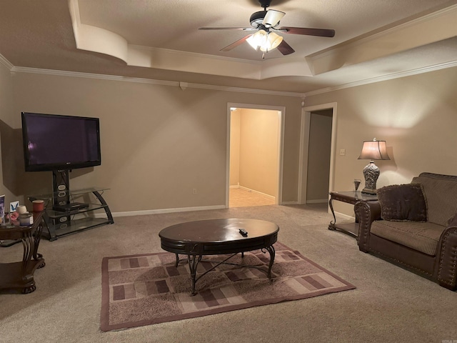 carpeted living room featuring ceiling fan, ornamental molding, and a tray ceiling