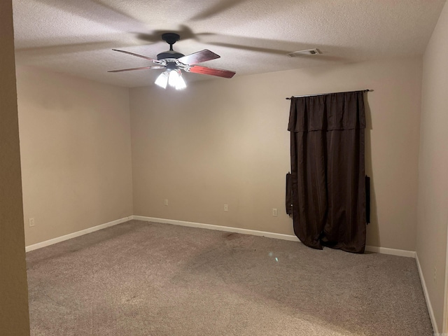 spare room with ceiling fan, carpet, and a textured ceiling