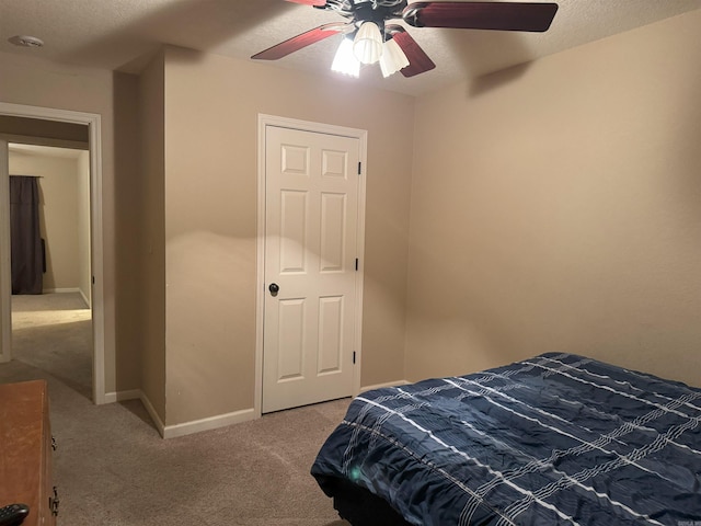 carpeted bedroom with a textured ceiling and ceiling fan