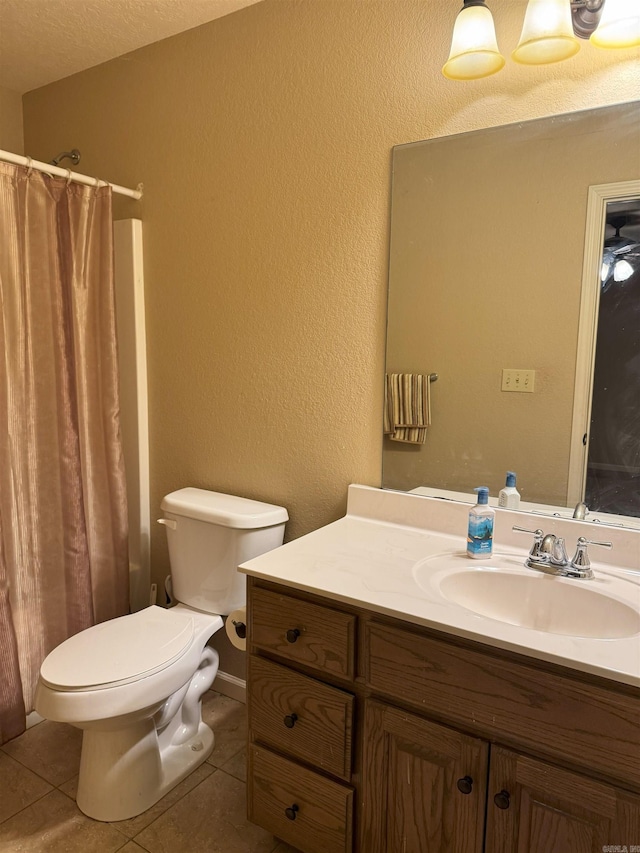 bathroom with curtained shower, a textured ceiling, tile patterned flooring, toilet, and vanity