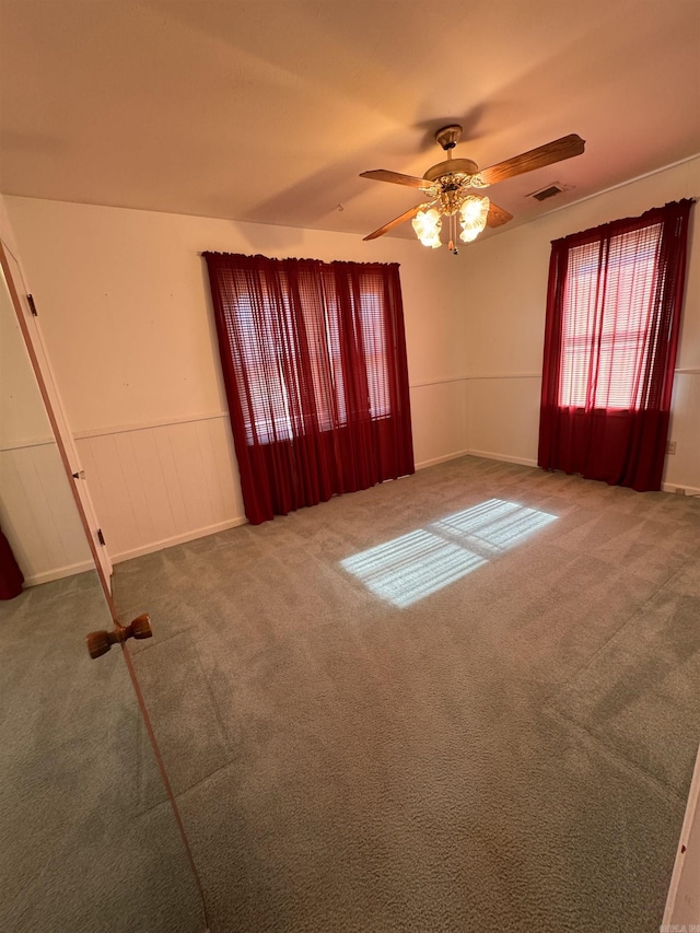 carpeted spare room featuring ceiling fan