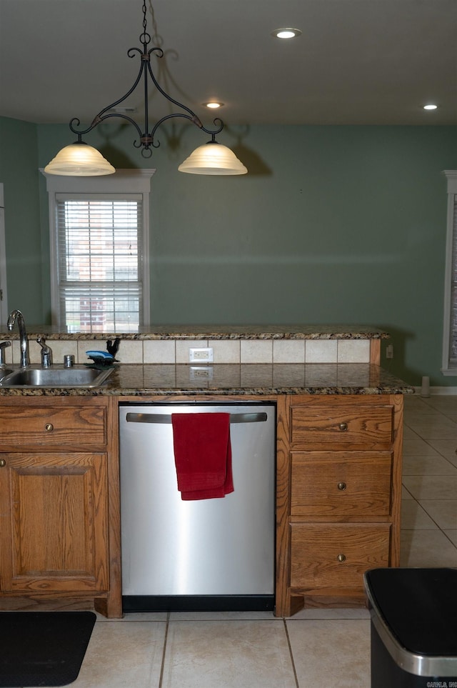 kitchen featuring sink, hanging light fixtures, stainless steel dishwasher, and light tile patterned flooring