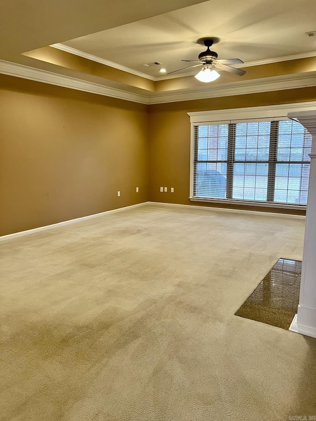 carpeted spare room with ceiling fan, a tray ceiling, and crown molding