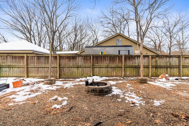 yard covered in snow with a fire pit