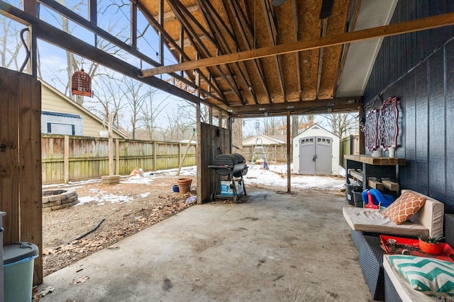 view of patio with a fire pit, area for grilling, and a shed