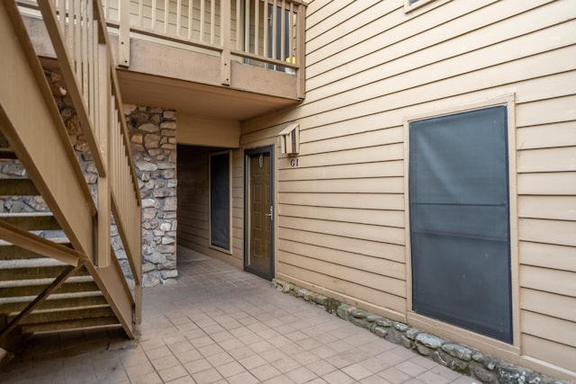 view of exterior entry with a balcony and a patio area