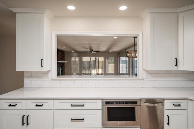 kitchen featuring decorative backsplash, white cabinetry, ceiling fan, and appliances with stainless steel finishes