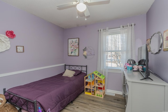 bedroom with light wood-type flooring, ceiling fan, and multiple windows