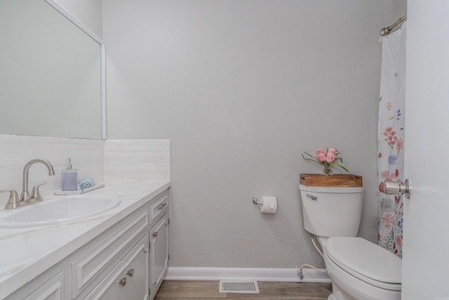 bathroom featuring toilet, vanity, and hardwood / wood-style floors