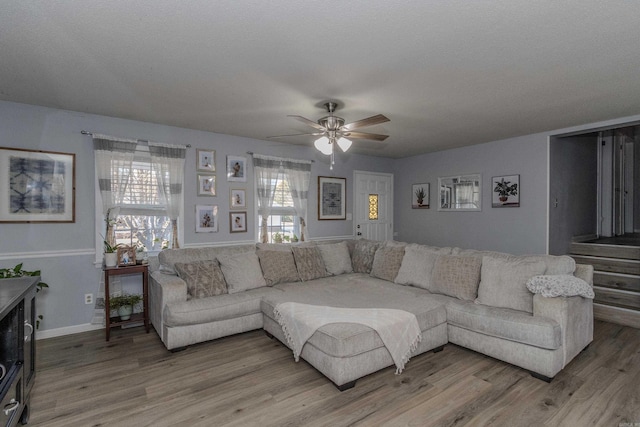 living room featuring hardwood / wood-style flooring, a textured ceiling, and ceiling fan