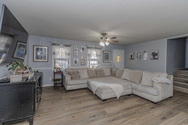 living room featuring hardwood / wood-style floors and ceiling fan