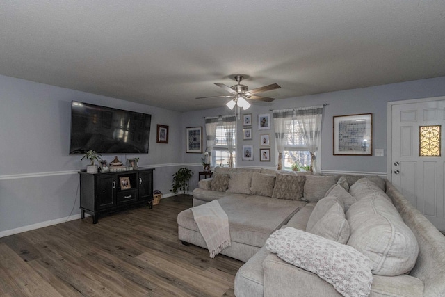 living room with a textured ceiling, ceiling fan, and dark hardwood / wood-style floors