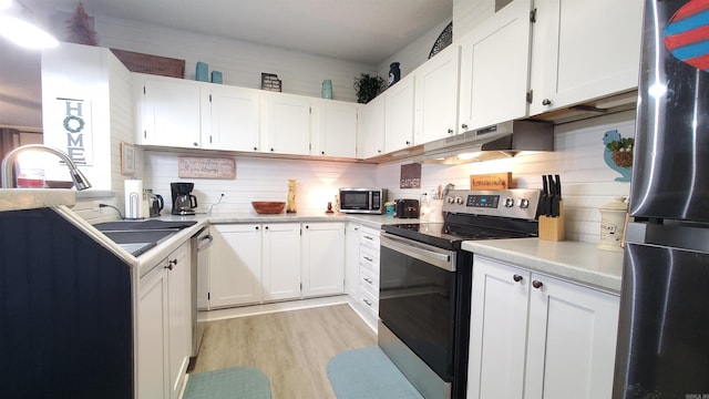 kitchen with decorative backsplash, white cabinetry, light wood-type flooring, and appliances with stainless steel finishes