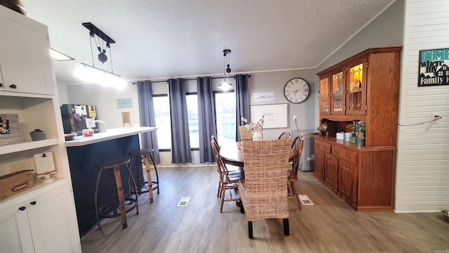 dining area with a textured ceiling and light wood-type flooring