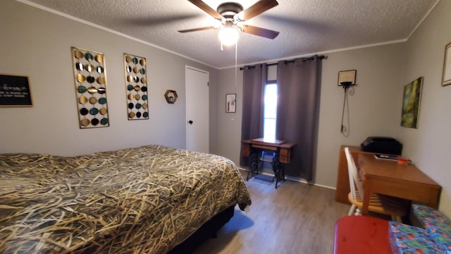 bedroom featuring ornamental molding, a textured ceiling, ceiling fan, and wood-type flooring