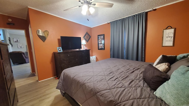 bedroom featuring a textured ceiling, ceiling fan, and light hardwood / wood-style flooring