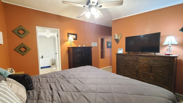 bedroom with ceiling fan, ensuite bathroom, and a textured ceiling