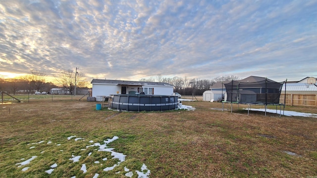 yard at dusk featuring a storage shed