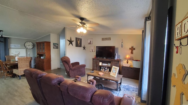 living room featuring lofted ceiling, a textured ceiling, and ceiling fan