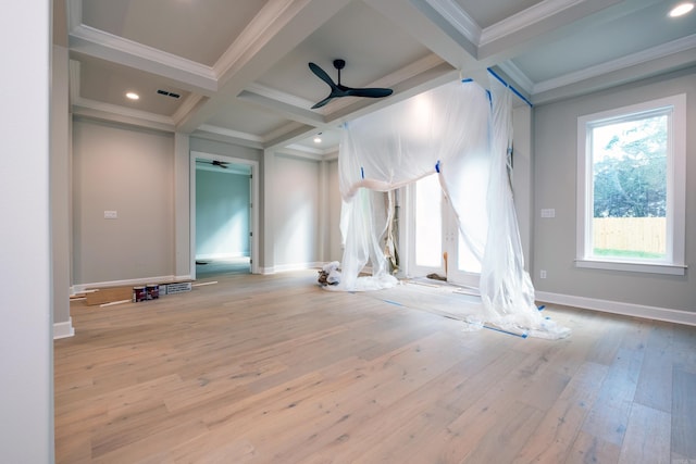 unfurnished living room featuring coffered ceiling, light wood-type flooring, ceiling fan, a healthy amount of sunlight, and beam ceiling