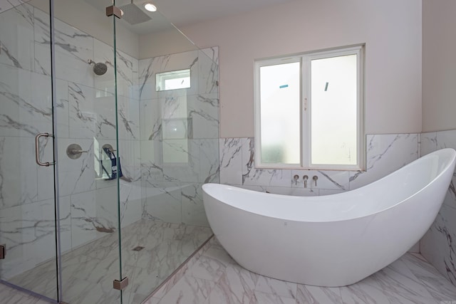 bathroom featuring tile walls and separate shower and tub