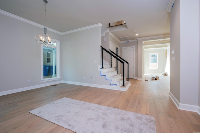 entrance foyer featuring ornamental molding, a chandelier, and light hardwood / wood-style floors