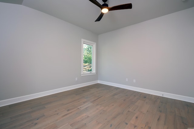 unfurnished room with lofted ceiling, dark hardwood / wood-style floors, and ceiling fan