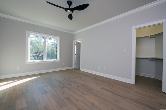 unfurnished bedroom featuring a walk in closet, a closet, and ceiling fan