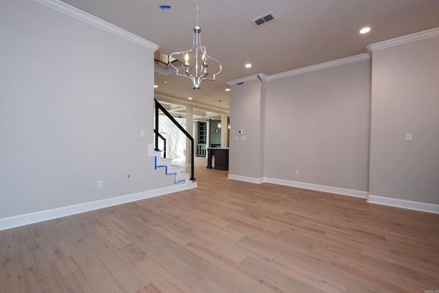 unfurnished living room with crown molding, light hardwood / wood-style flooring, and a notable chandelier